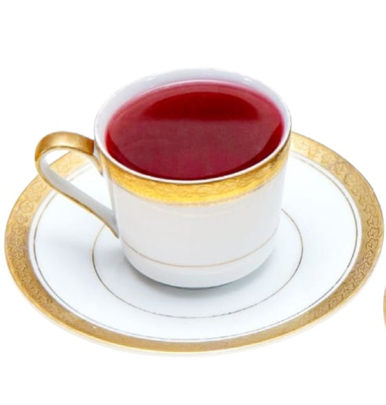 Hibiscus Orange Spice Blend in a cup with saucer on white surface.